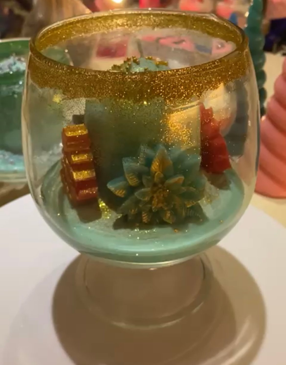 Christmas candle in a glass with trees & flowers